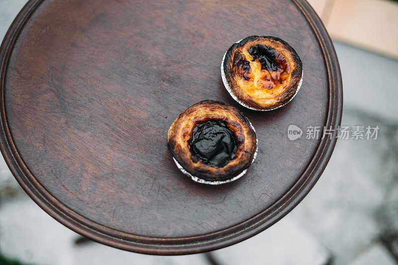 柔和的de nata。传统的葡萄牙蛋糕放在古老的木桌上